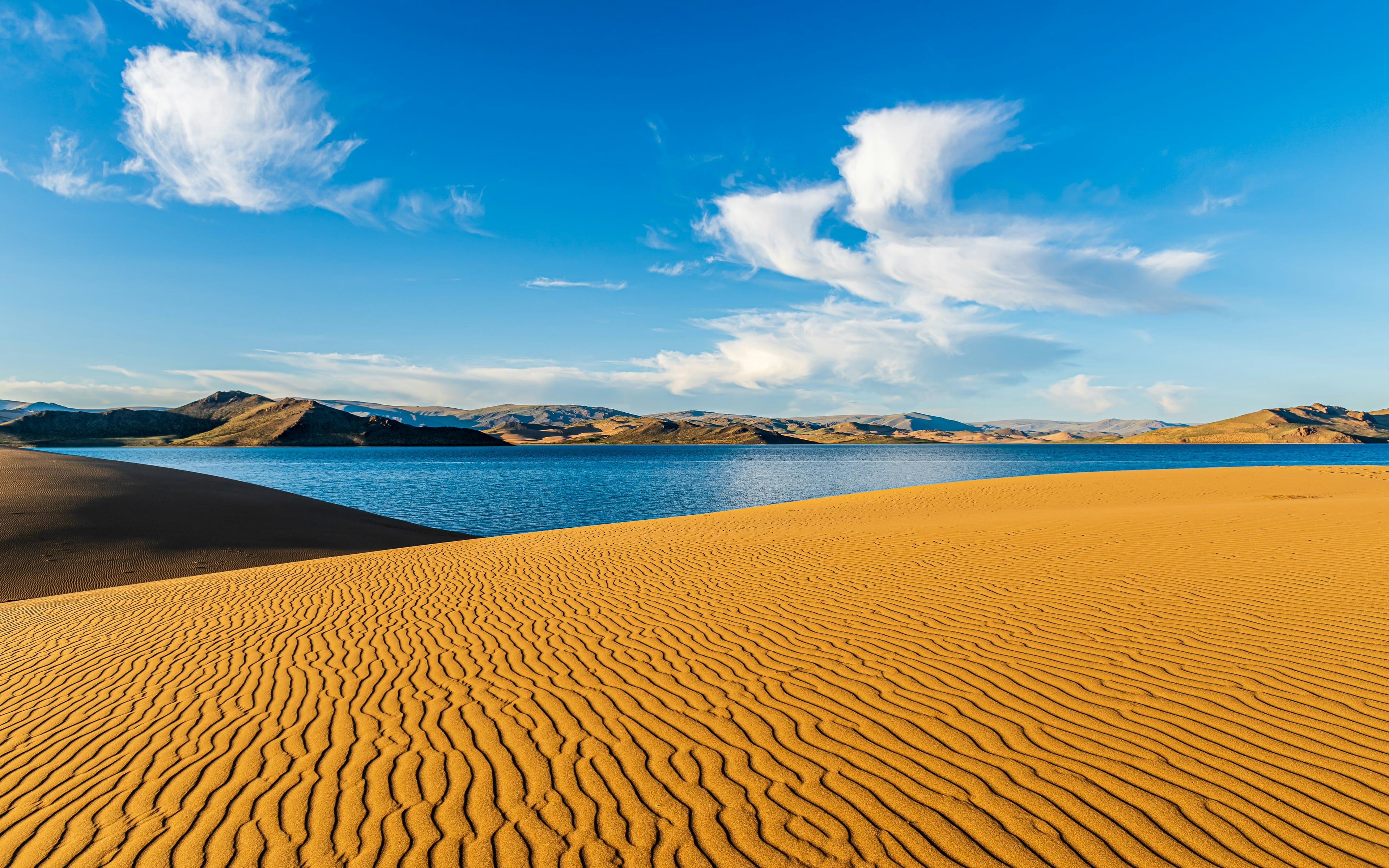 Sun setting over Utah dunes and a calm desert lake